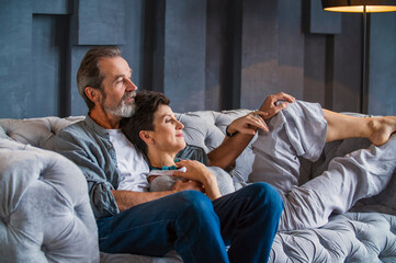 Wall Mural - elderly couple sitting on the sofa