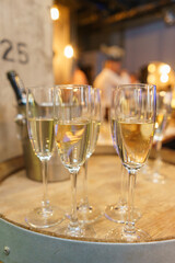 few transparent glasses with champagne on a rack in a bar or restaurant prepared for guests of festive events.