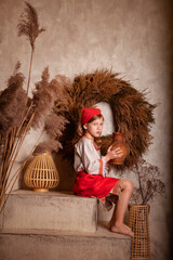 Wall Mural - little girl in a light linen shirt and a red scarf in a rustic style