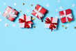 © Denira - Red christmas gift box with confetti on blue background