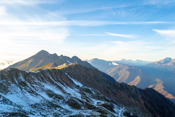 Top of snowy high mountain and clouds in sunny day