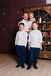 © Alyona - man and three children stand in the room. guys in white shirts, school uniforms.father and three children