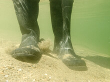 Rubber Boots Or Gumboots Underwater On Sand Ground