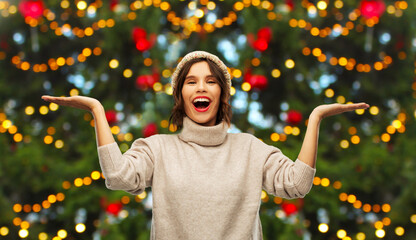 Sticker - winter holidays and people concept - smiling woman over christmas tree lights on background