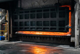 Fototapeta  - Big industrial furnace glowing red hot while heating and melting some scrap metal 