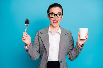 Canvas Print - Portrait of attractive hungry cheerful funny lady eating tasty yummy lunch yogurt licking lip isolated on bright blue color background