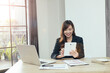 © PaeGAG - An Asian businesswoman talks to a team of co-workers about video conferencing plans, work at home ideas.