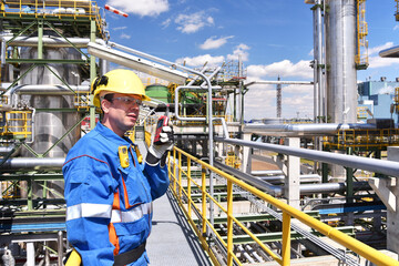 chemical industry plant - workers in work clothes in a refinery with pipes and machinery