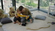 © stockbusters - Two siblings hugging in children room. Nice brothers sitting on floor at home.