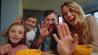 © stockbusters - Parents, kids looking camera home. Family waving hands during morning video call