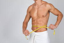 Muscular Man Measuring His Waist With Yellow Tape