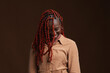 © Seventyfour - Waist up portrait of stylish African-American woman with braided hair smiling happily while standing against dark brown background in studio, copy space