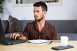 © Dumblin Films - Handsome male working on laptop from home