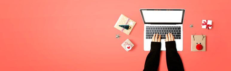 Person using a laptop computer with Christmas gift boxes from above