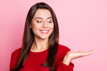 Wall Mural - Photo portrait of nice beautiful girl with brunette hair smiling holding hand near shoulder showing copyspace looking down isolated on pink color background