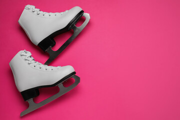Wall Mural - pair of figure ice skates on pink background, flat lay. space for text