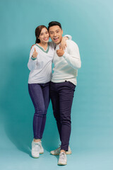 portrait of happy young stylish couple in love having fun in studio isolated on blue background