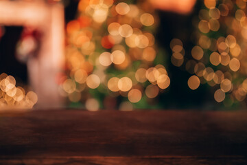 Wall Mural - Beautiful blurred Christmas background. In the foreground is a wooden table. In the background there is a Christmas tree and a fireplace