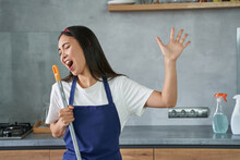 Have Fun. Portrait Of Joyful Young Woman, Cleaning Lady Pretending To Sing, Holding Broom While Cleaning The Floor, Doing Household Chores