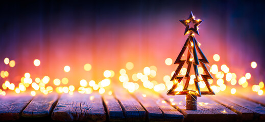 Wall Mural - christmas light and wooden tree on table with defocused rustic background