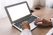 © uladzimirzuyeu - Blank laptop screen. A woman works behind a empty laptop at a desk.