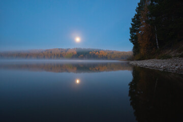 Wall Mural - scenic view of the river banks with trees covered in autumn colored leafs and mist during sunrise an