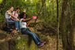 © René Stevens - Happy friends having fun in nature - Group of friends waving and smiling while having a selfie in the forest.