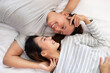 © JR-50 - The Close-up of the happy an Asian couple is lying in bed together. They meet each other's eyes showing love.