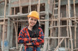 © Odua Images - beautiful female asian contractors wearing safety helmets with crossed hands in the background of building construction