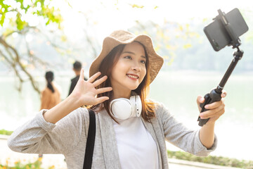 Asian woman recording video on the street in Hanoi, Vietnam