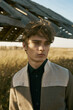 © Дарья Чачева - Portrait of young beautiful man in village area. Yellow field. Sun light, blue sky, autumn. Checkered pants, black shirt and jacket