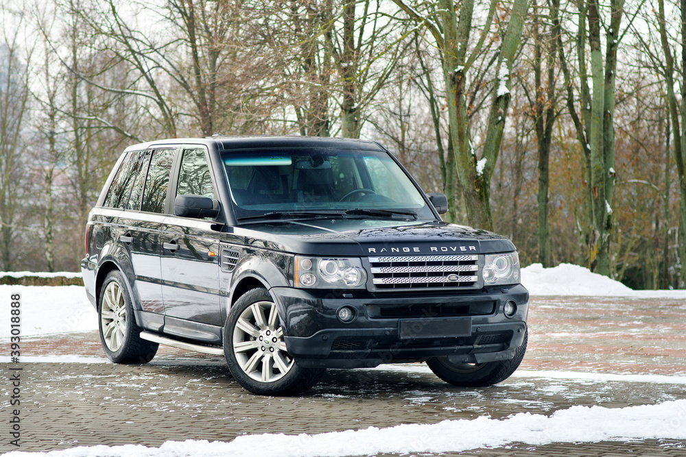 Grodno, Belarus, December 2012: Land Rover Range Rover Sport V8 Supercharged. Three fourth view of black SUV over out of focus winter park background with copy space.