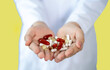 © Lucky7Trader - Many pills and vitamins in the hands of doctor. Isolate on yellow background