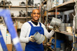 © JackF - Cheerful Latino workman preparing for pipework routing, choosing supplies in shop of building materials