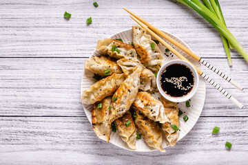 Fried dumplings gyoza with soy sauce, and chopsticks.