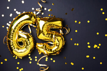 Gold foil balloon number, digit sixty-five. Birthday greeting card with inscription 65. Anniversary celebration event. Banner. Golden numeral, black background. Numerical digit, light bokeh, glitter