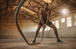 © Jacob Lund - Strong and masculine athlete working out with battle rope