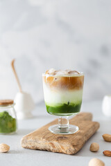 Matcha espresso. Trendy coffee drink with spirulina. Green tea coffee, matcha green tea with milk and coffee. Colorful layer drink. Menu, recipe. Side view, copy space