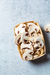 Canvas Print - Raw chopped champignons in wicker basket, top view. Vegan ingredient concept.