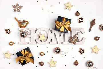  The words Home surrounded by gold festive decorations on a white background. Top view, flat layer.