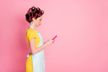 Poster - Profile side view portrait of pretty focused housemaid blogger using gadget blogging post smm browsing isolated on pink color background