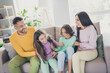 © deagreez - Photo of full big family four members sit couch enjoy tickling wear colorful sweater trousers in living room indoors