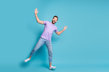 Wall Mural - Full length body size photo of young student dancing fooling wearing jeans casual t-shirt sneakers isolated on bright blue color background