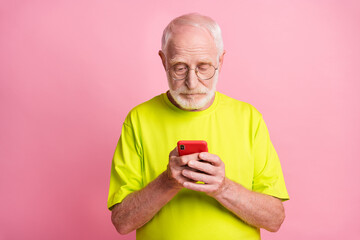 Poster - Photo of serious concentrated aged guy typing message wear lime clothing isolated on pink color background