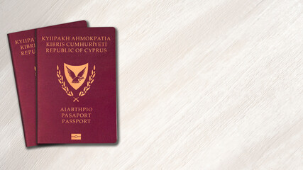 two Cyprus passports on white wood background, space for texts