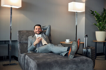 Wall Mural - Happy adult man having a rest with a smartphone