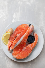 Sticker - fresh salmon with lemon, ginger and soy sauce on white plate