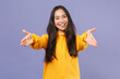 © ViDi Studio - Smiling joyful beautiful attractive young brunette asian woman 20s in casual yellow hoodie standing reach out stretch hands looking camera isolated on pastel violet colour background studio portrait.