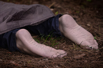 Wall Mural - Barefoot dead body in the woods. Murder victim. Murdered citizen, crime scene