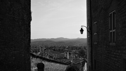 Wall Mural - A glimpse of the medieval village of Gubbio from an alley with stone houses and a street lantern hanging on a wall (Umbria, Italy, Europe)